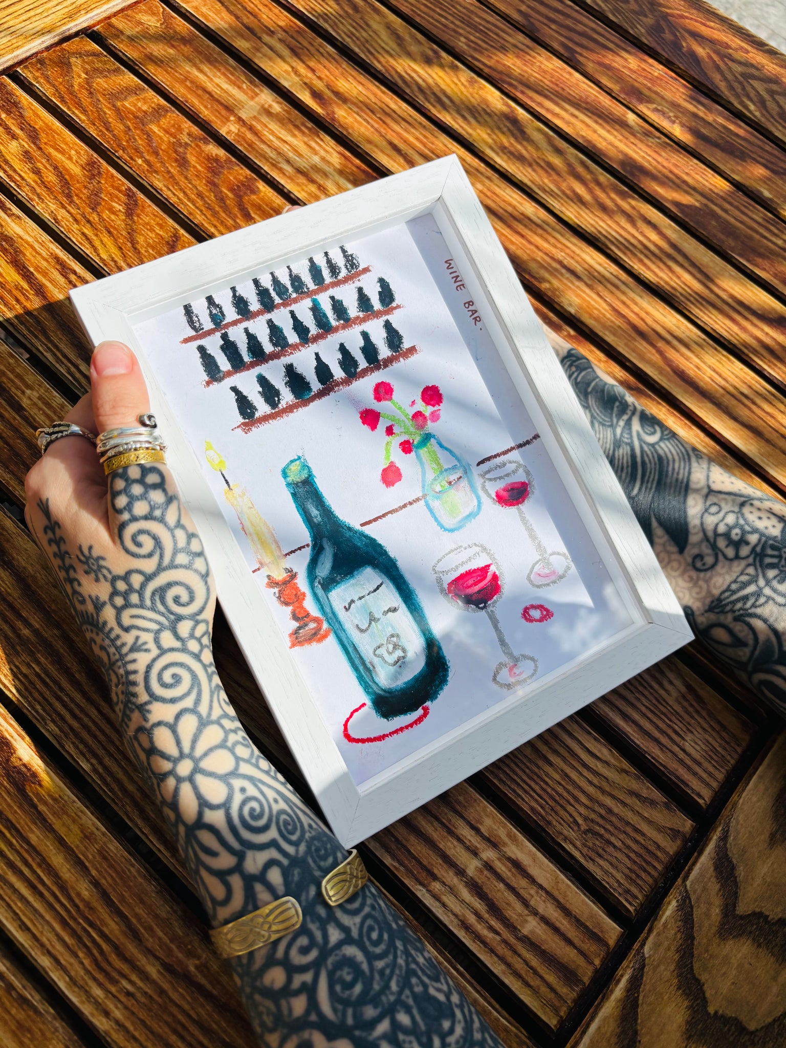 Framed artwork of bottles and glasses on a wooden table